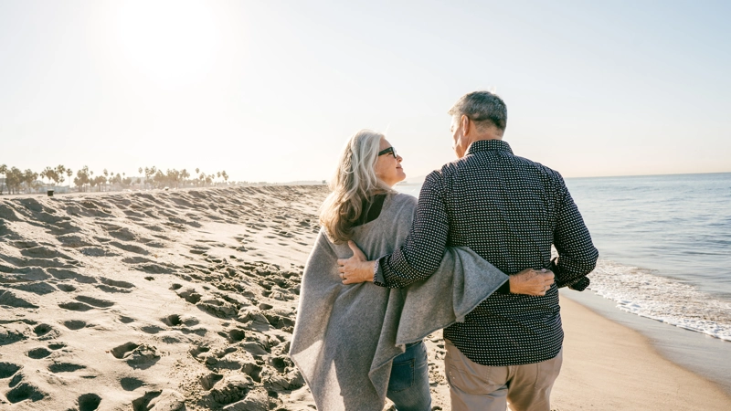 Elderly couple walking on the beach.